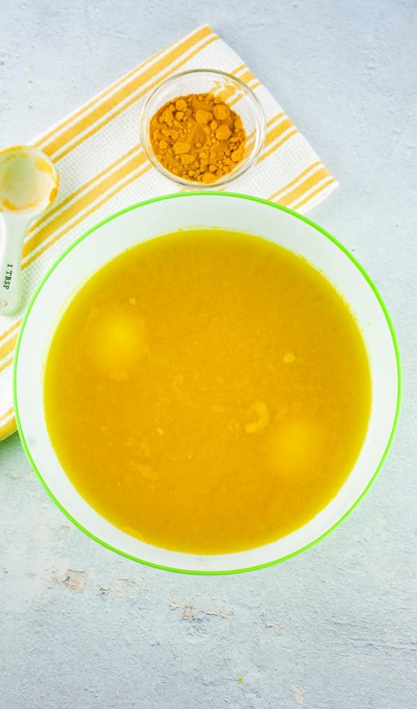 eggs dying in a stockpot full of water, vinegar and turmeric for all-natural dyed eggs