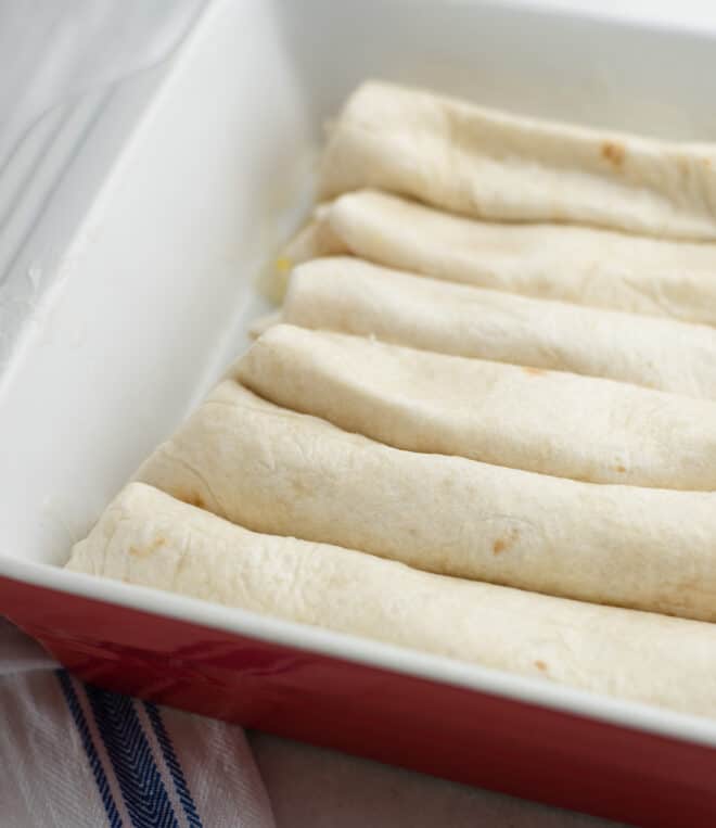 rolled peach filled tortillas placed seam side down in an 8x8 baking pan
