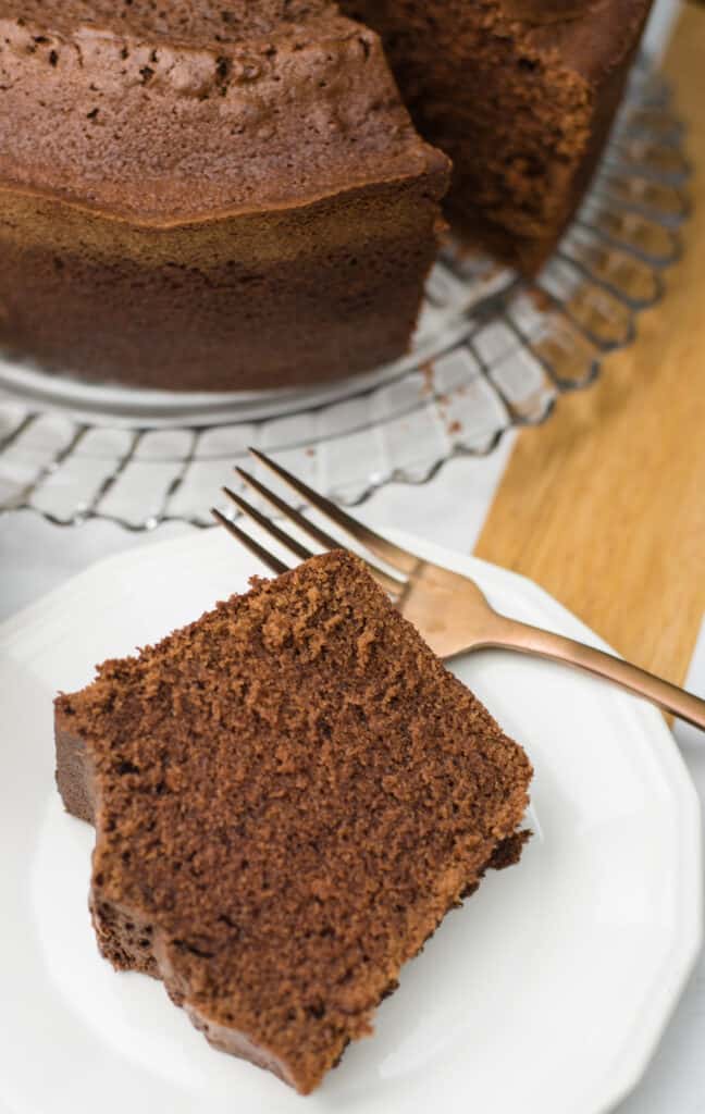 chocolate sour cream pound cake featuring a slice of cake with the entire cake in the background