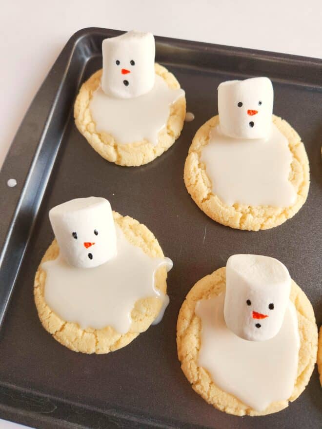 melted snowman cookies on a baking sheet