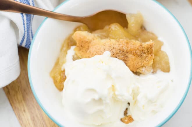 serving of apple cobbler and vanilla ice cream in a white bowl 