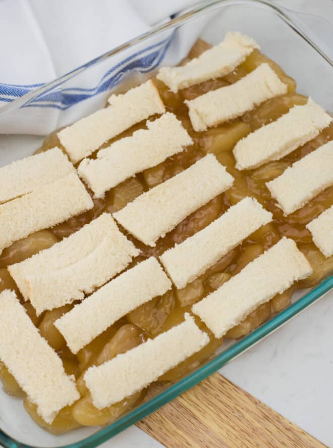 white bread sliced and placed on top of apple pie filling in a 9x13 baking pan