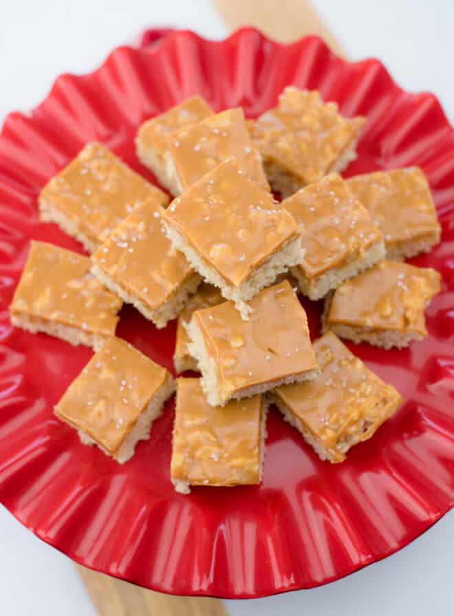 rice krispie treats topped with salted caramel on a red platter