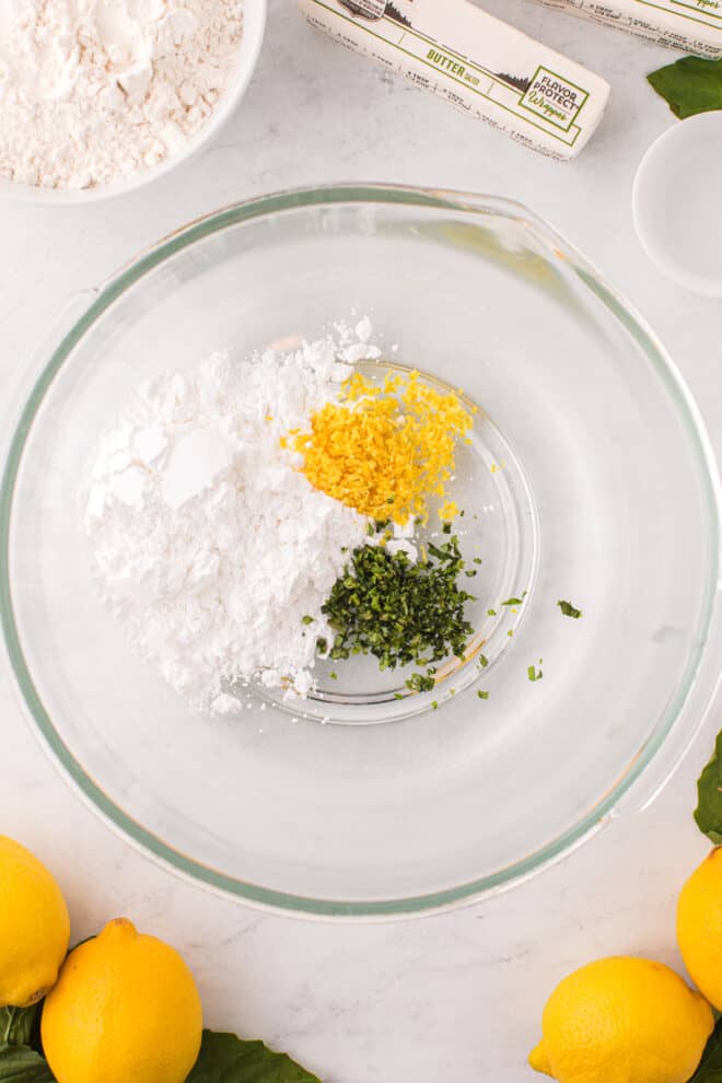 lemon zest, powdered sugar and minced basil in a clear glass bowl. 