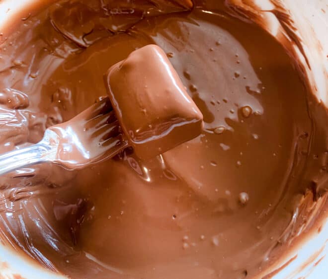 bars being dipped into melted chocolate