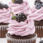 Closeup photo of chocolate cupcakes topped with blackberry buttercream