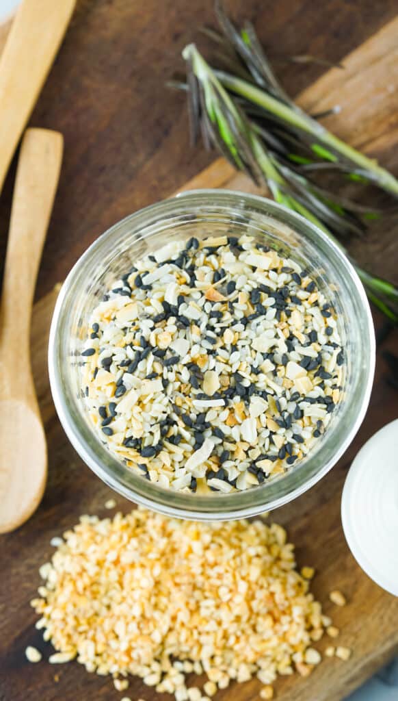 Overhead shot of everything bagel seasoning mix in a mason jar with teaspoon on the side