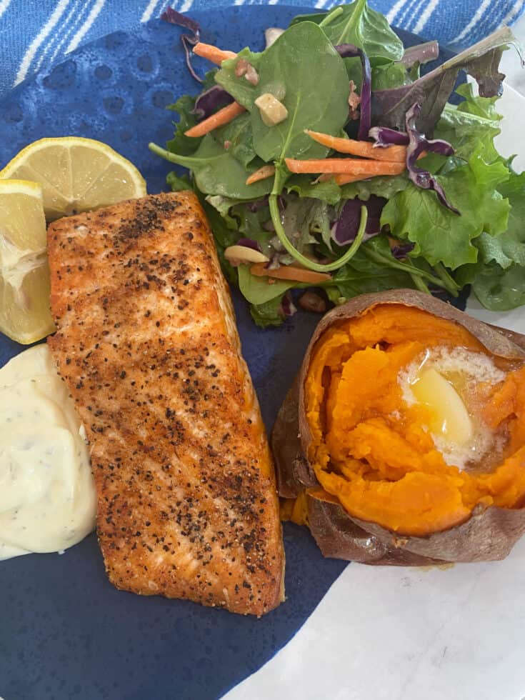 Air Fryer Salmon plated with a sweet potato and green salad