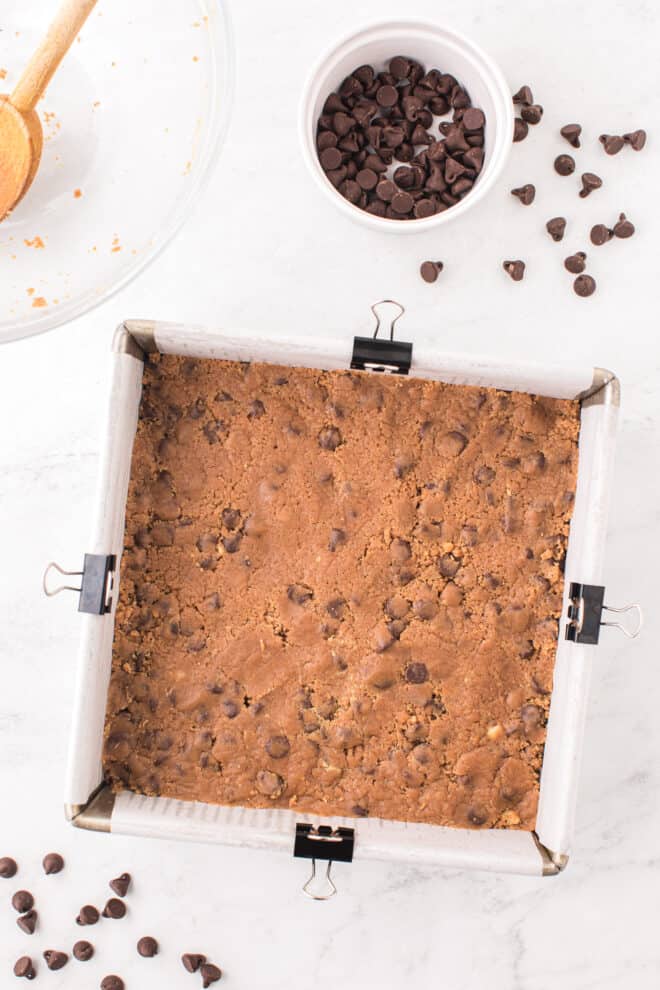 cookie bar dough pressed into a 9x9 pan before baking