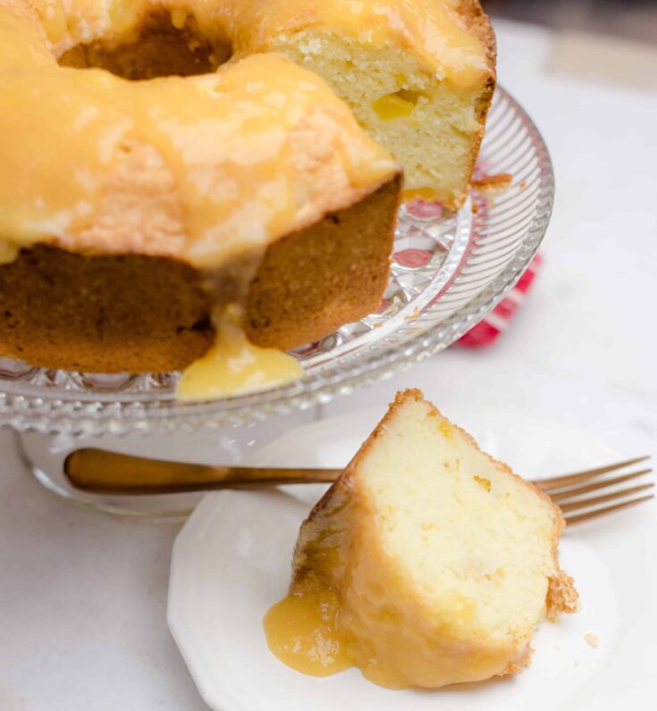 Peach Pound Cake With Peach Glaze with a serving slice in front of the cake