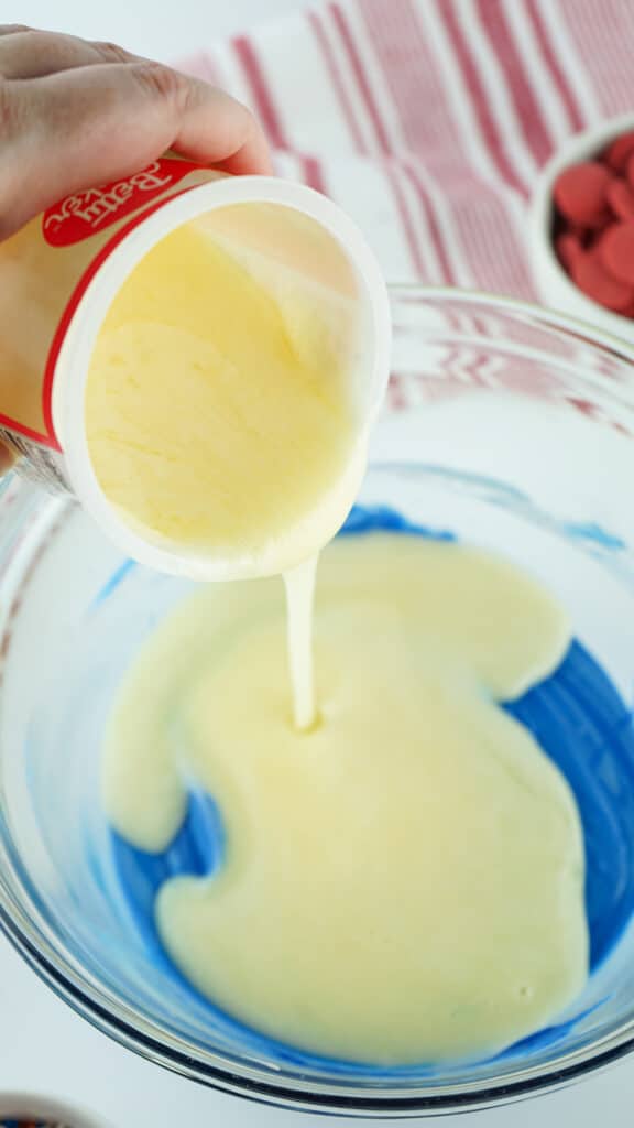 add blue dye to white chocolate mixture in glass bowl