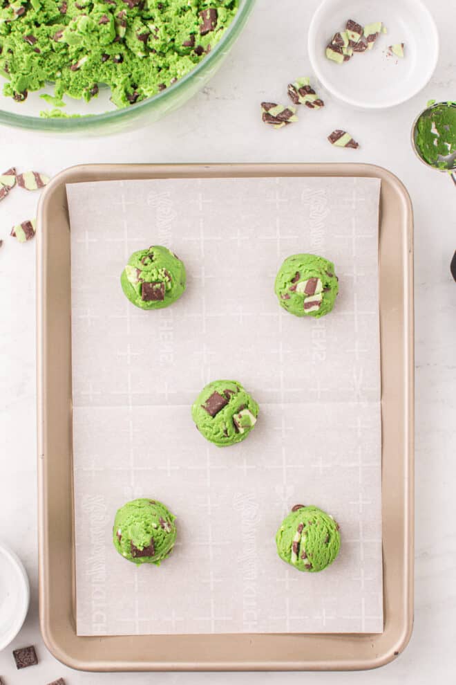 cookie dough balls on parchment lined baking sheet