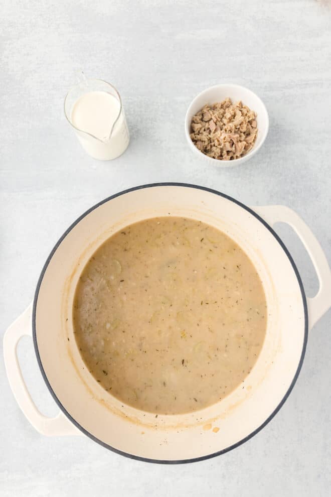 adding clams to liquid to make clam chowder