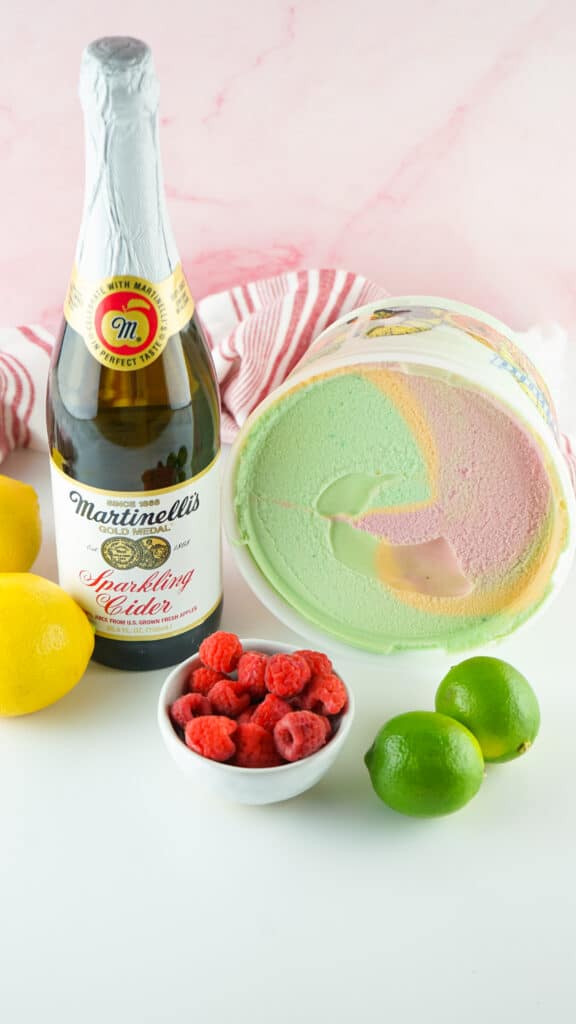 Ingredients to make Sparkling Cider Floats - sparkling apple cider, rainbow sherbet, lemons, limes and raspberries