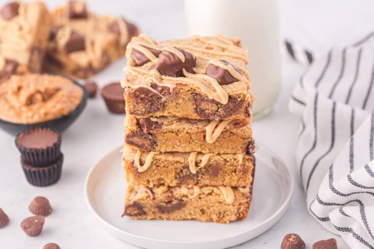peanut butter blondies stacked on a white serving plate