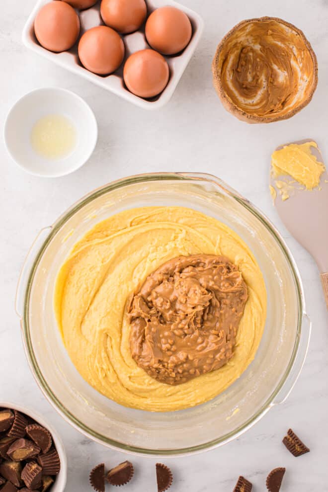 peanut butter added to batter in glass bowl to make peanut butter blondies