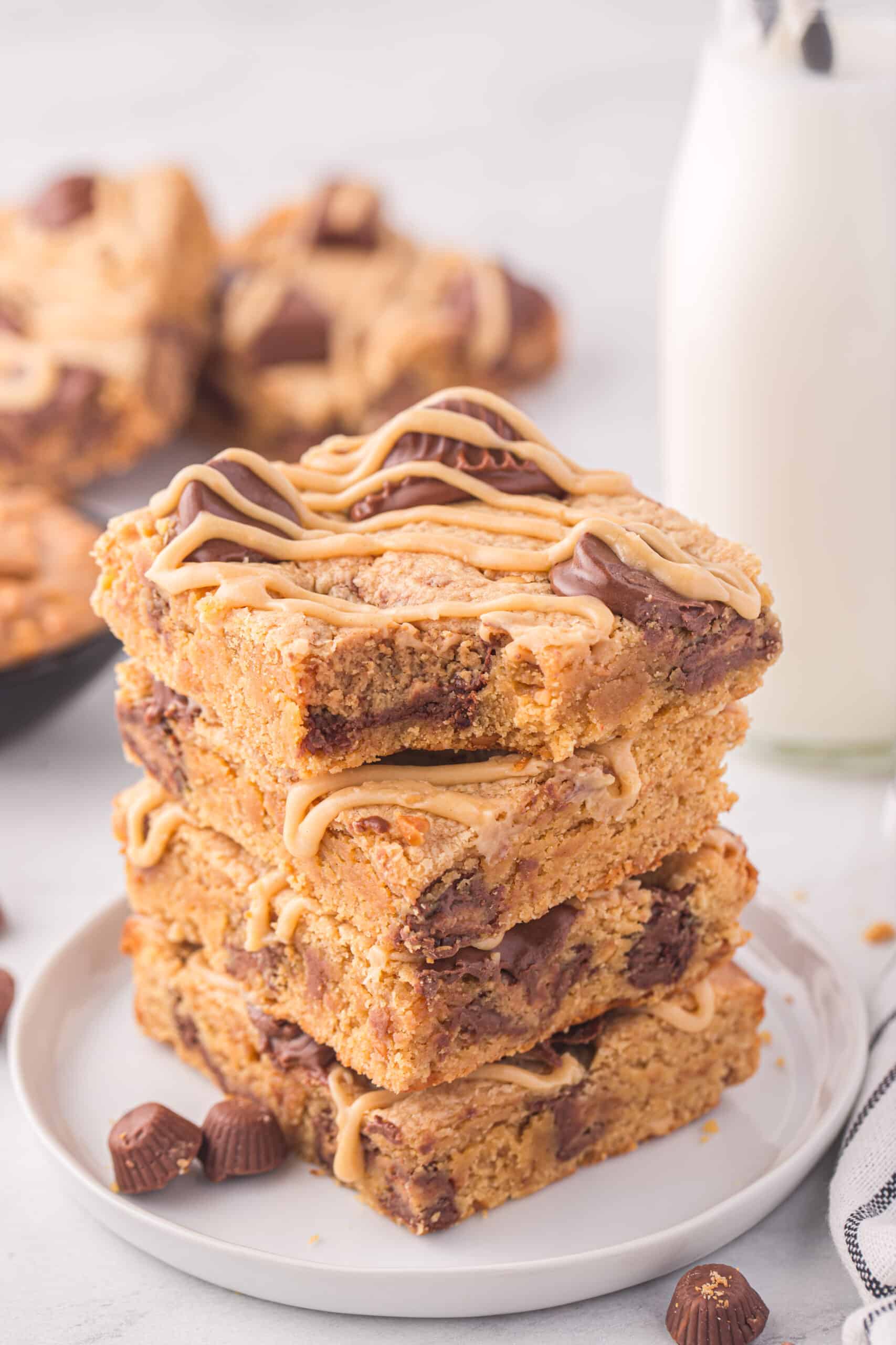Peanut Butter Blondies With Reese's Cups stacked on a serving tray