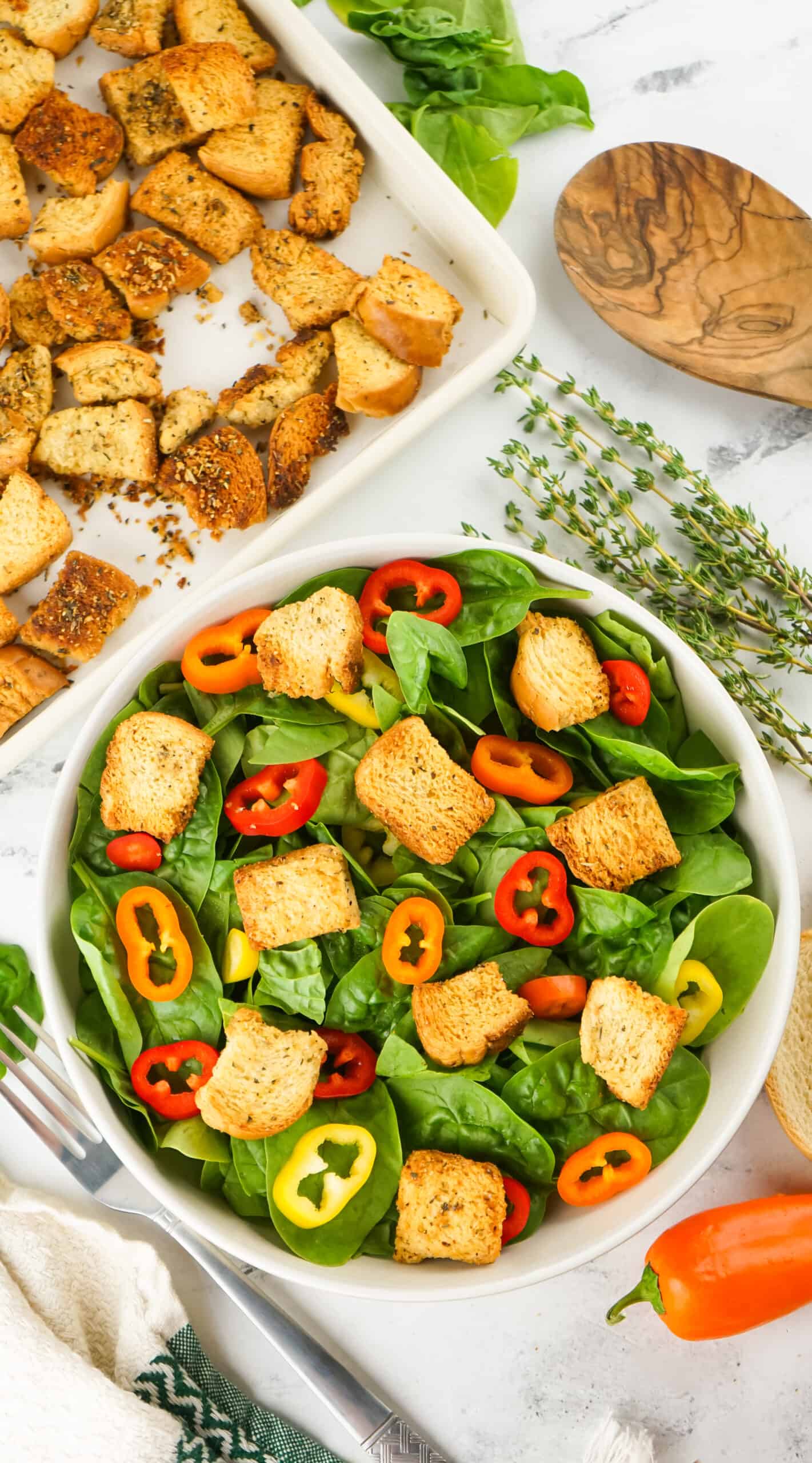 green salad in a white salad bowl topped with homemade croutons 
