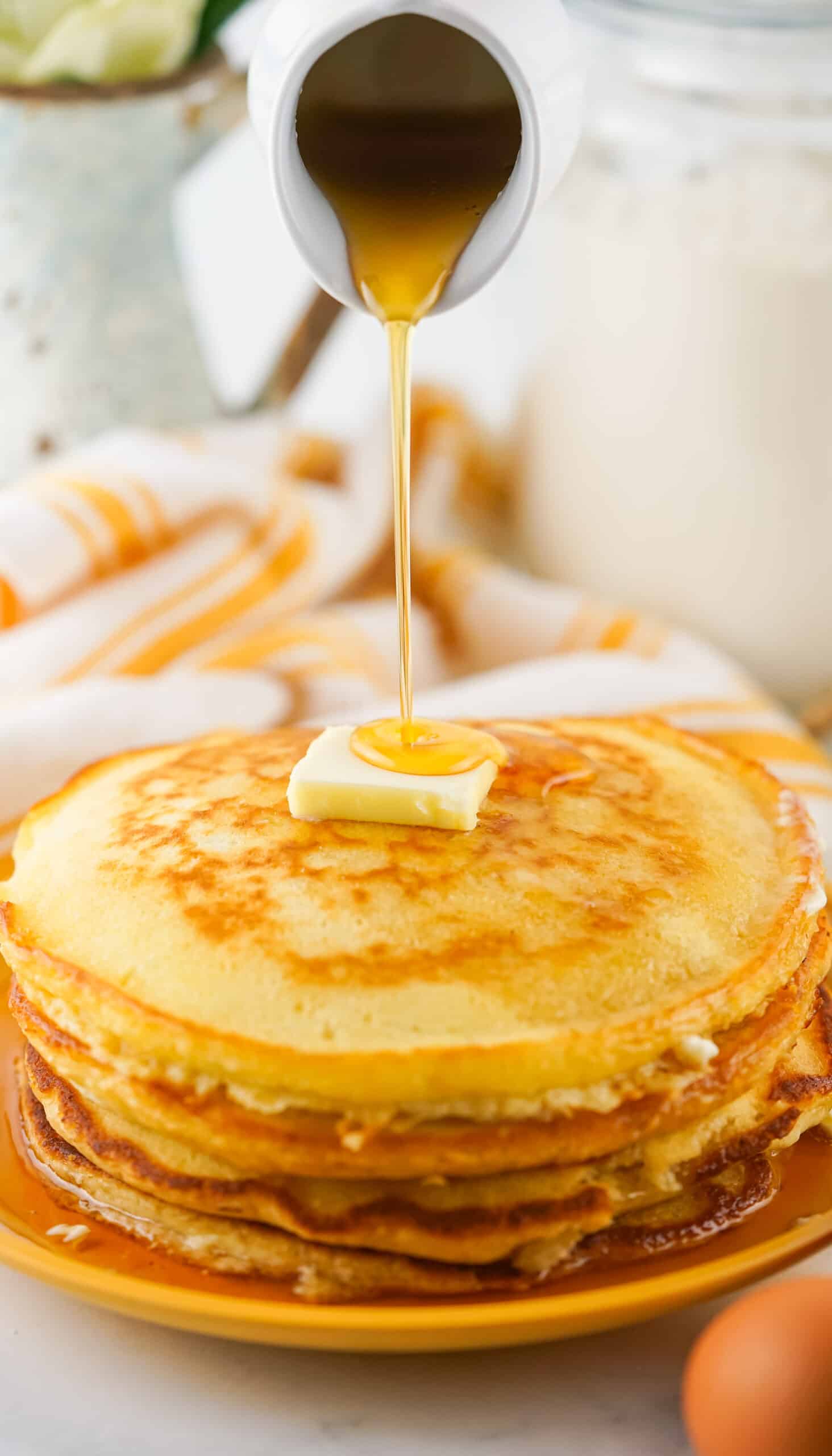 Golden Pancakes made from homemade bulk pancake mix with syrup being drizzled over the top