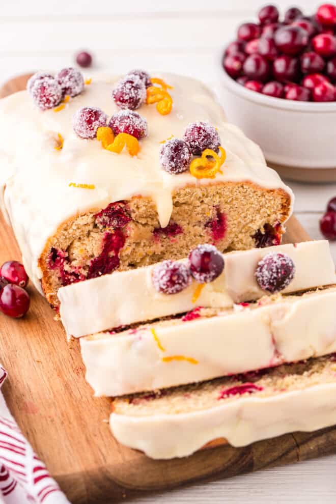 cranberry orange loaf cake sliced with glaze dripping down the slices