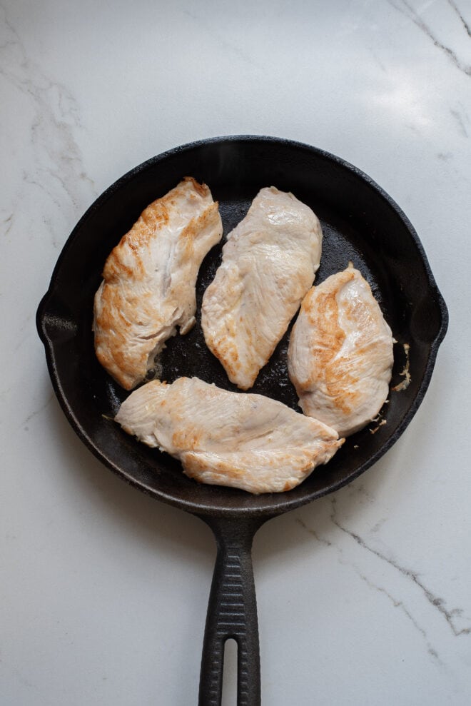 boneless chicken breasts searing in skillet