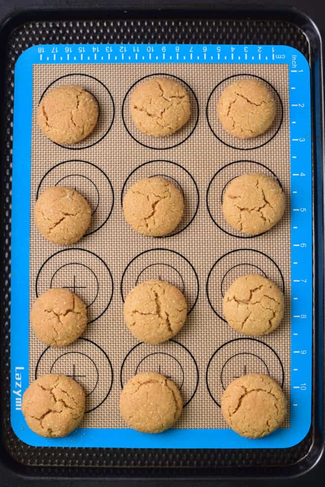 peanut butter cookies on baking sheet, baked and ready to add Hershey's Kisses