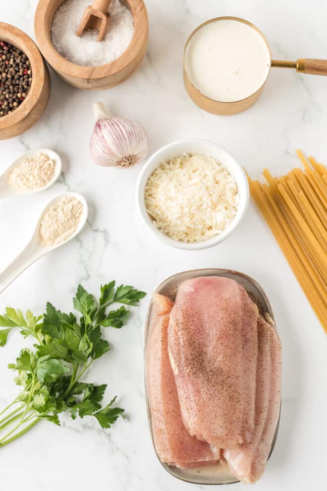 photo of ingredients needed to make grilled chicken fettuccine Alfredo including boneless skinless chicken breasts. 