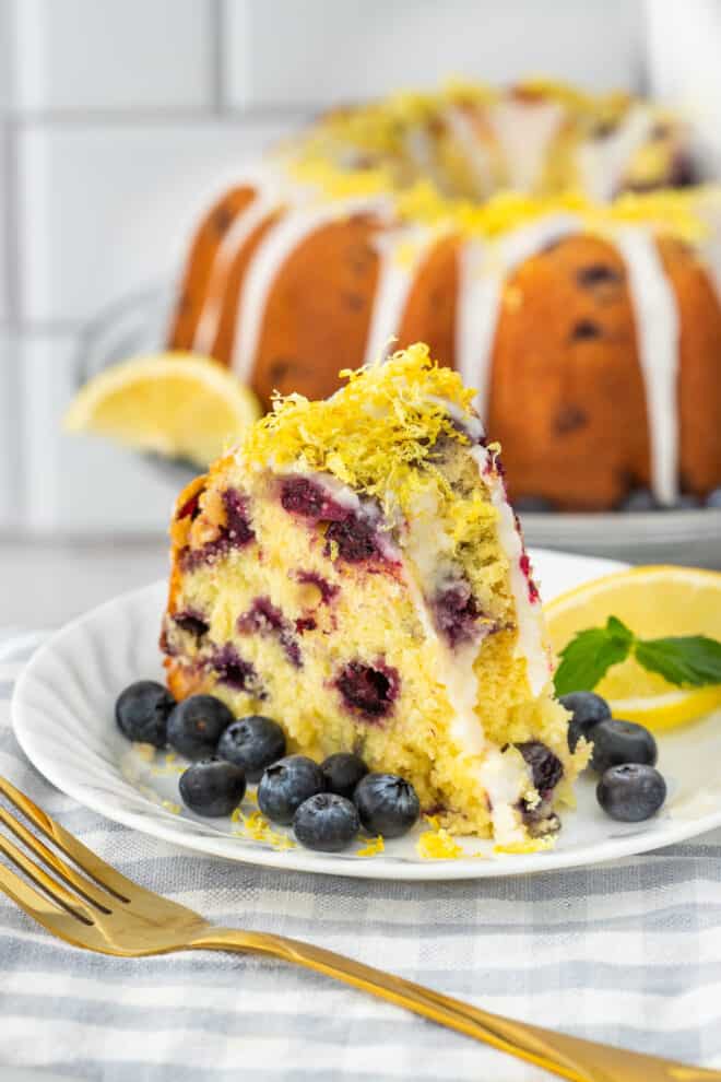 Slice of Lemon Bundt Cake With Blueberries and topped with a lemon glaze and lemon zest