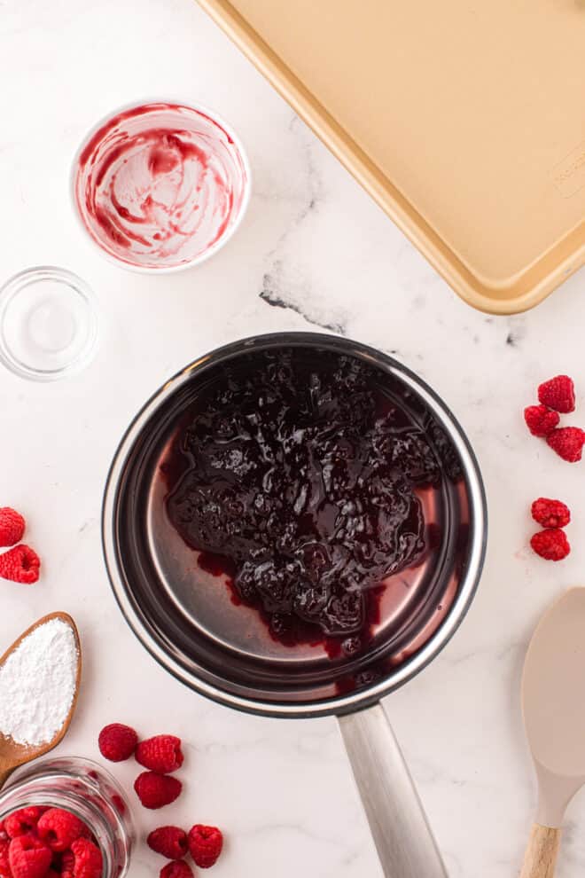 Saucepan with ingredients to make a raspberry drizzle