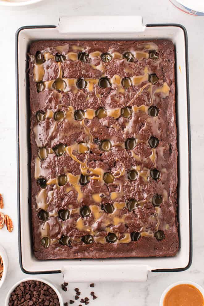 caramel sauce poured over holes poked into a chocolate cake