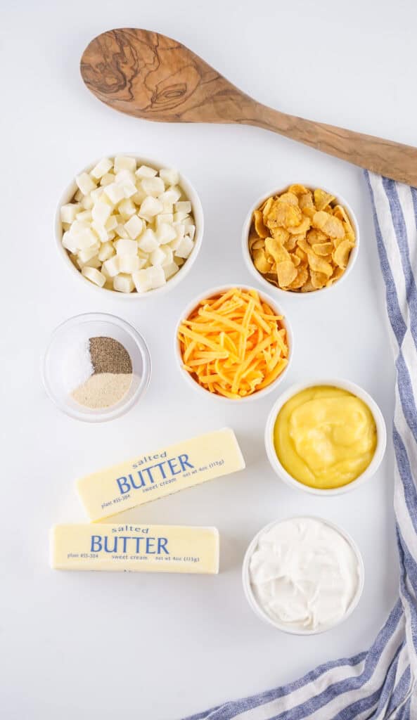 measured ingredients for funeral potatoes including frozen hash brown potatoes, cheese, sour cream, cream of chicken soup and butter