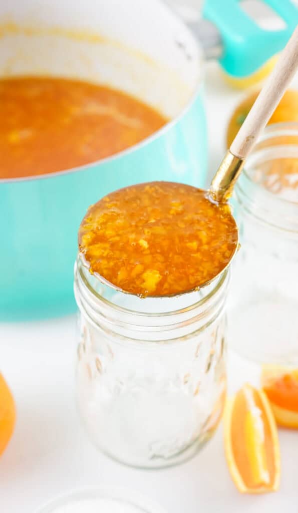 Filling mason jars with orange marmalade 
