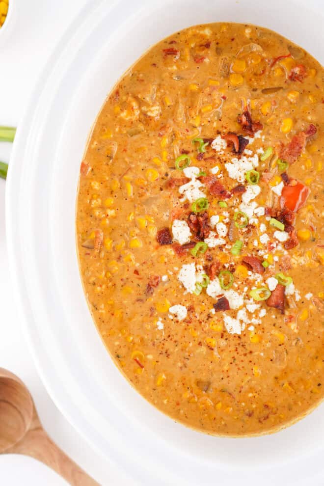 Mexican Street Corn Soup in a white slow cooker, ready to serve.