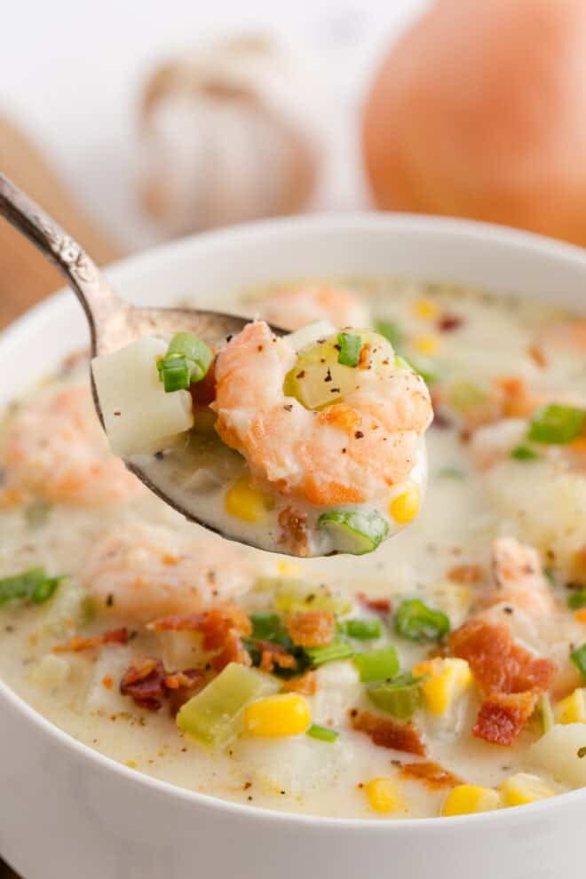 Shrimp Chowder being spooned out of a white bowl