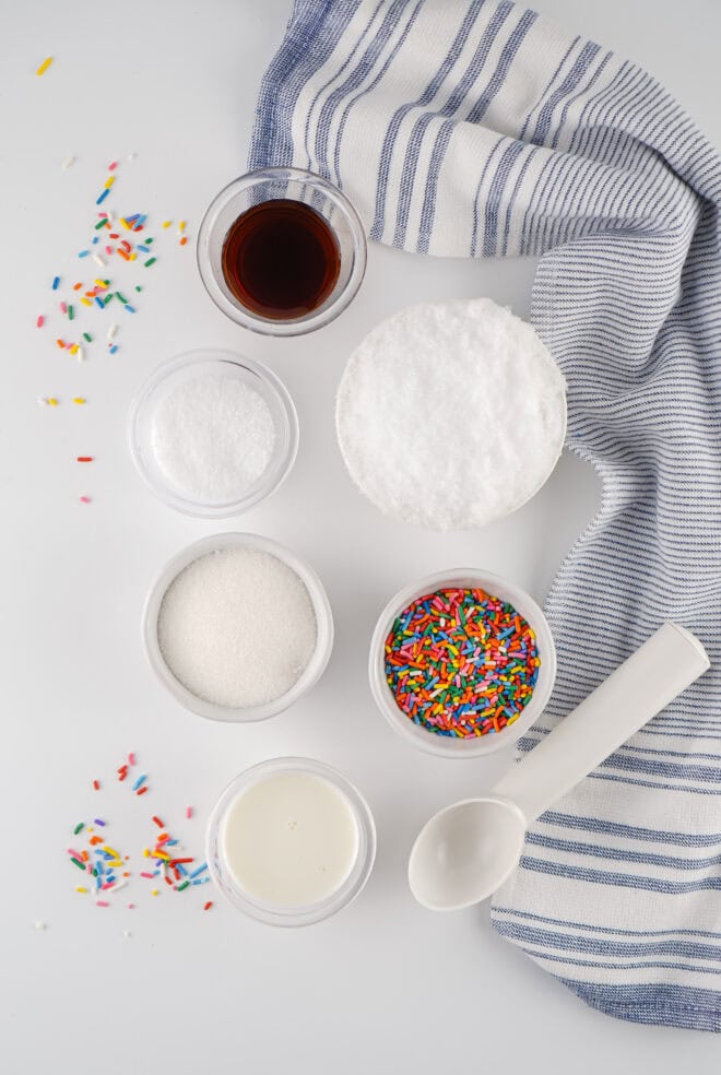 Ingredients to make snow ice cream - sugar, vanilla, snow, milk plus sprinkles and salt