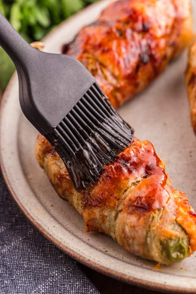 Brushing grilled Texas Twinkles with remaining BBQ sauce