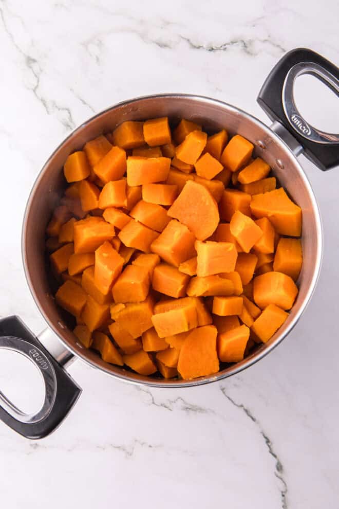 Drained, cubed sweet potatoes in stainless steel pot ready to whip
