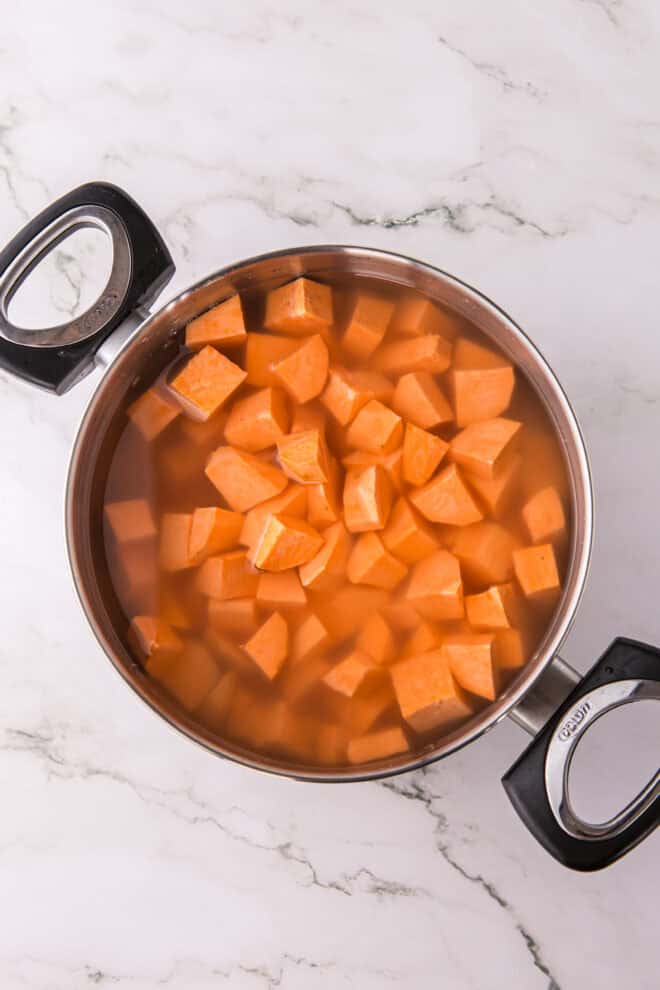 cubed sweet potatoes in a large pot covered with water, ready to boil until tender.