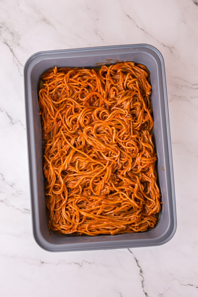 bottom layer of spaghetti and sauce in 13x9 pan
