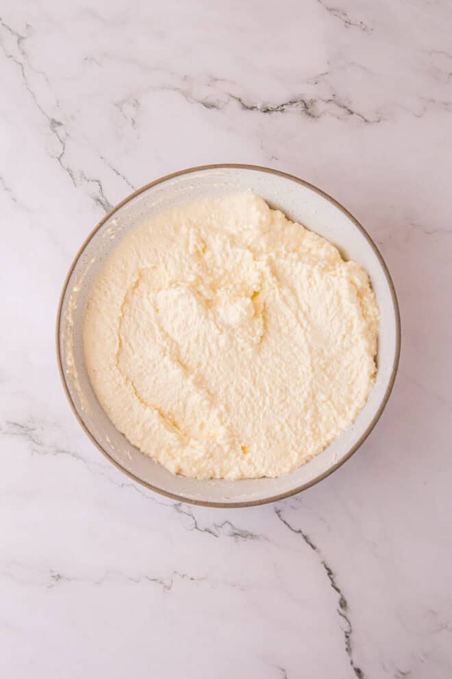 sour cream, ricotta and cream cheese mixed together in a small bowl