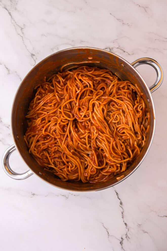 spaghetti and marinara sauce mixed together in a large pot.