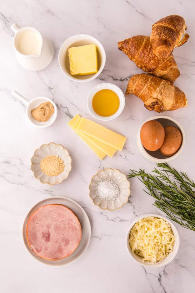 ingredients needed to make ham and cheese croissant bake including eggs, cheese, ham and day old croissants and heavy cream